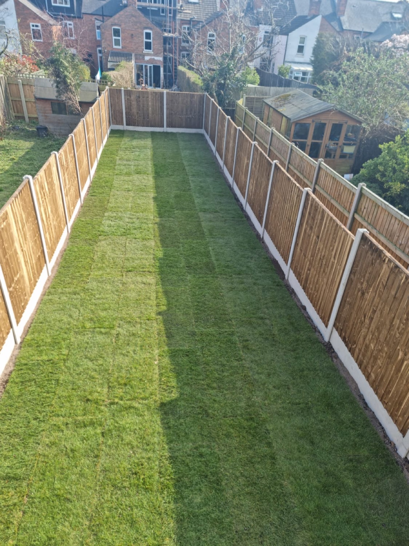 New timber panel fencing with concrete posts and a freshly laid lawn
